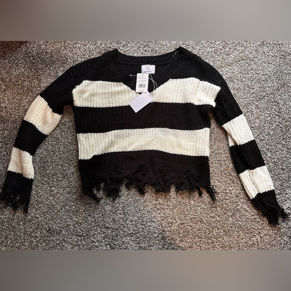 Black and white Sweater. Brand new. Size medium. Fringe sleeves and hem.